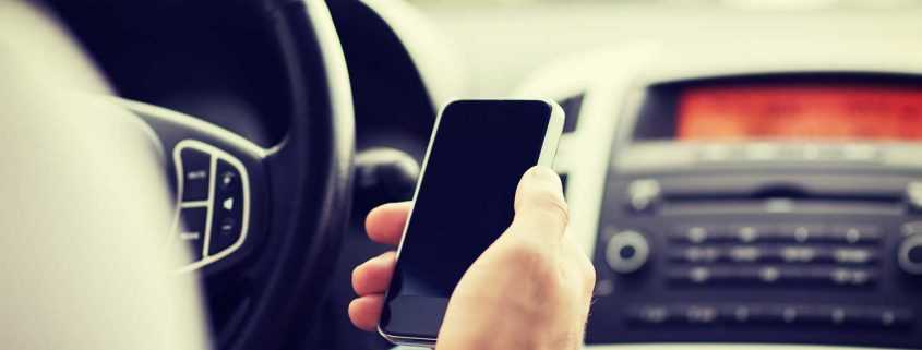 Man checking smartphone while sitting in car