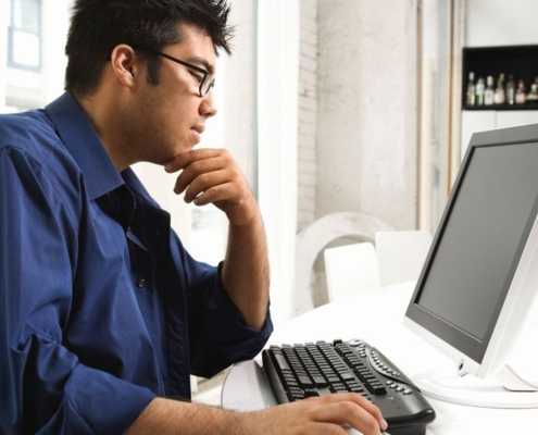 Man with glasses at a computer