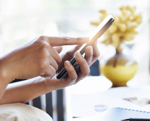 Hands holding a phone and touching the screen, to show how easy it is to remove your Ignition Interlock Device.