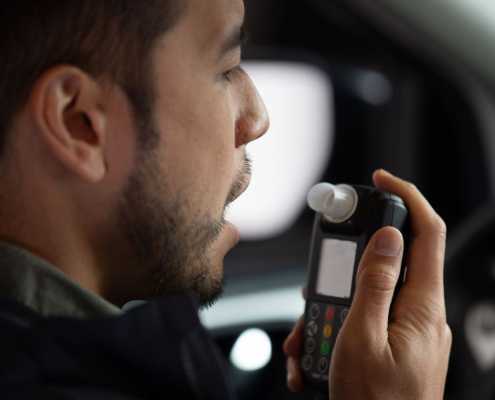 Driver getting ready to blow into Smart Start Ignition Interlock Device