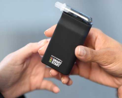 BreathCheck portable alcohol breathalyzer is handed to another person