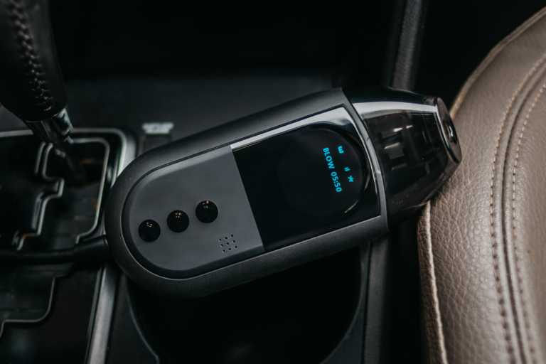 a Smart Start FLEX™ ignition interlock device resting on the middle console of a car