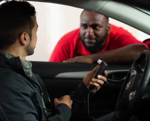 a man in a car with a Smart Start ignition Interlock device talking to a service agent